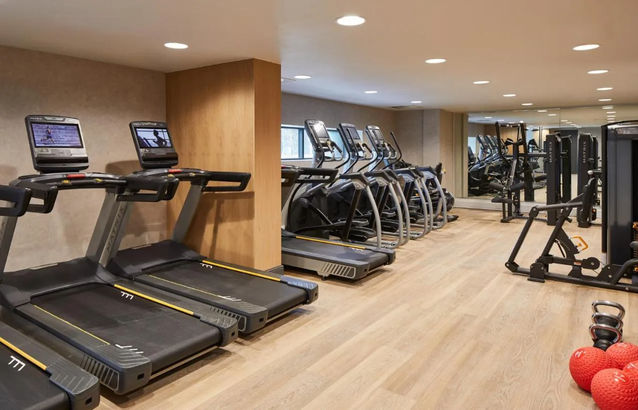 a row of treadmills in a gym with exercise bikes at Manchester Marriott Hotel Piccadilly in Manchester