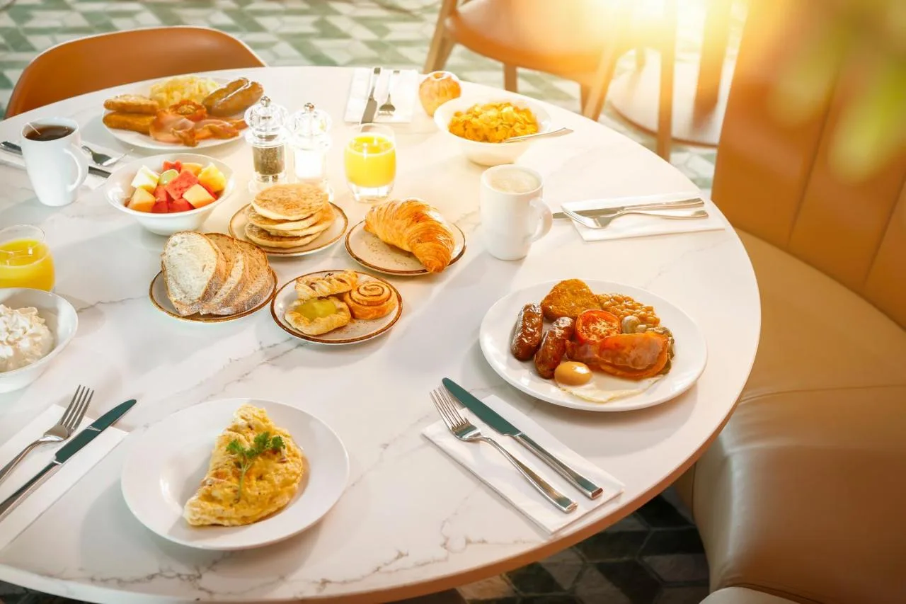 a white table with plates of breakfast food on it at Manchester Marriott Hotel Piccadilly in Manchester